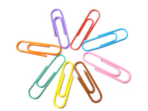Aligned colorful paperclips isolated in white